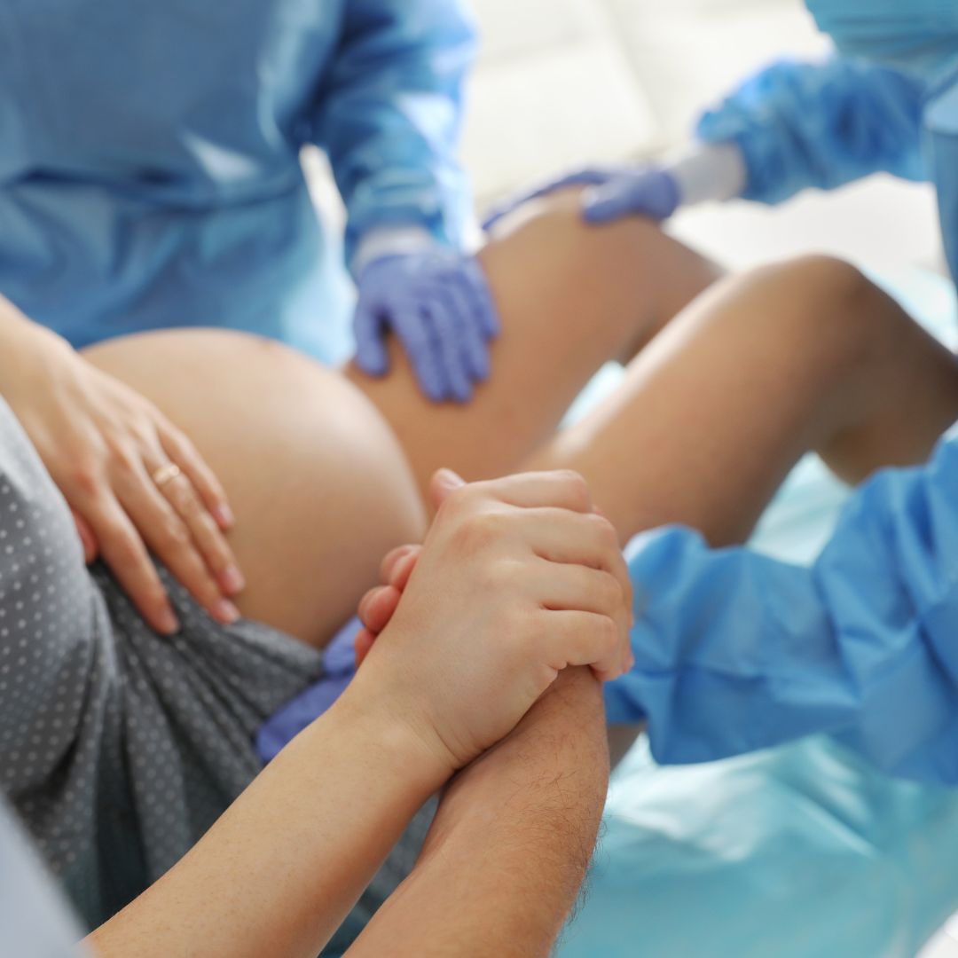 Woman giving birth with nurses and doctors